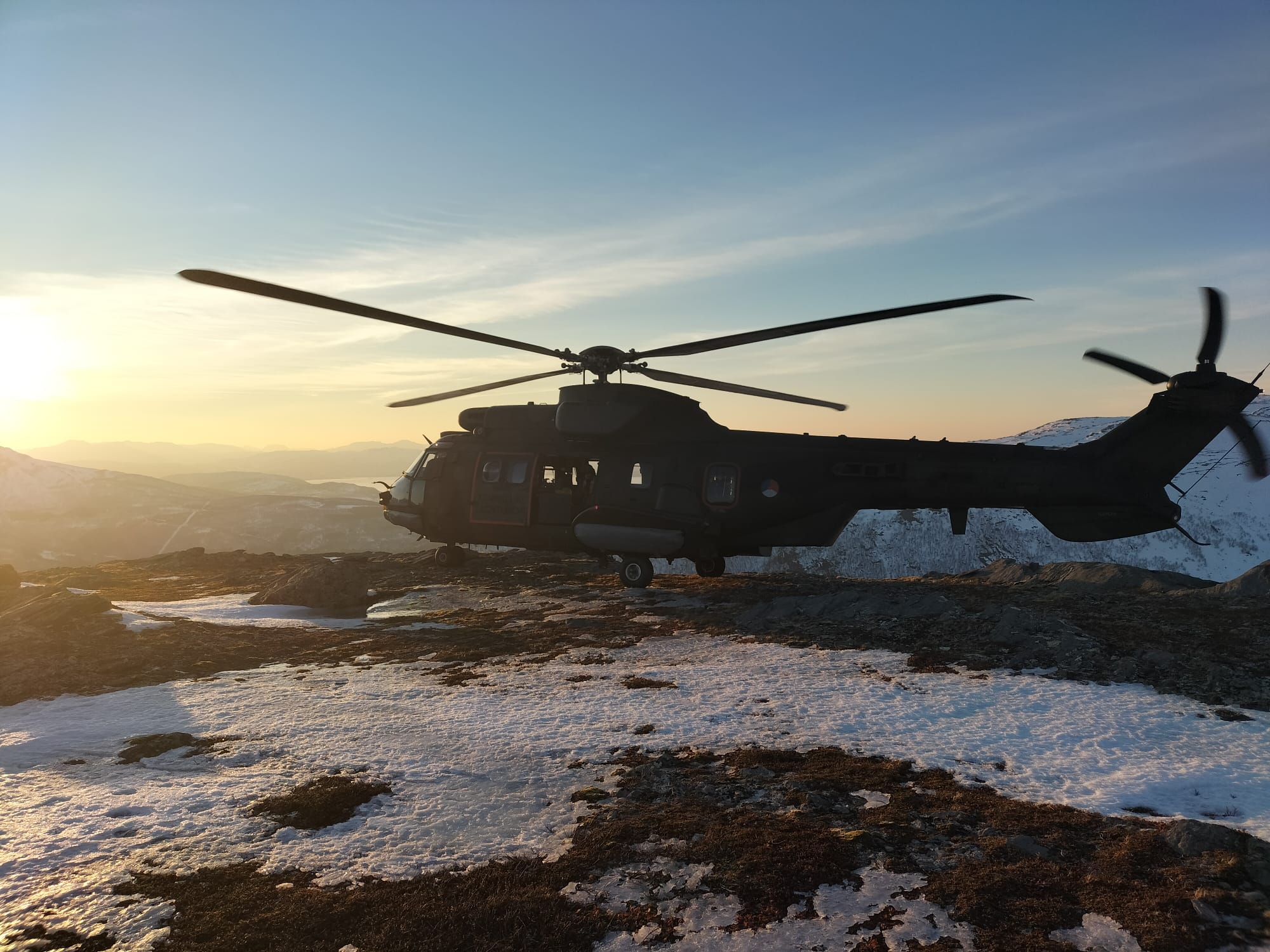 Cougar-helikopter in de sneeuw bij zonsondergang